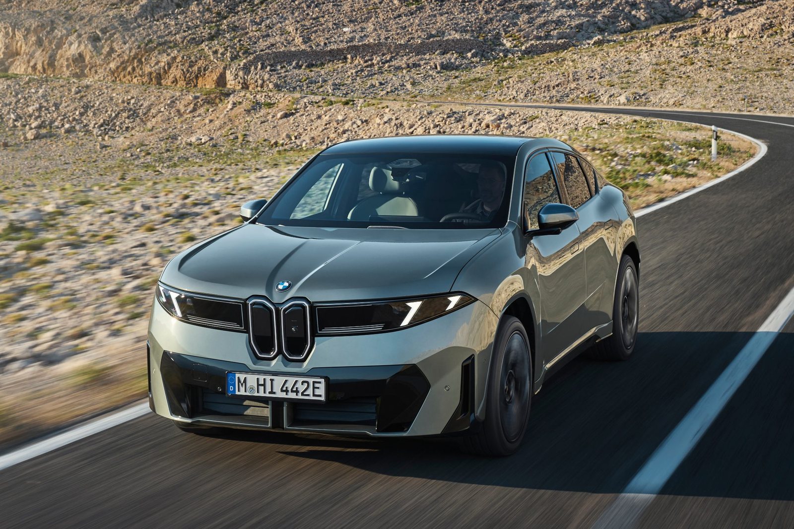 BMW iX4 50 xDrive in Fahrt auf einer Landstraße